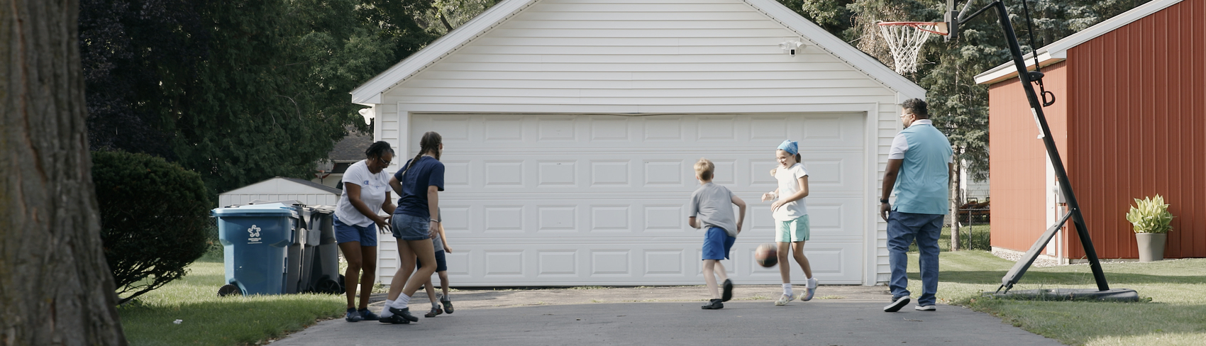 Foster parents play basketball with four siblings